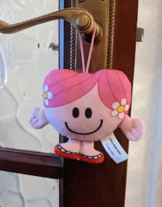 Little Miss Hugs plushie hangs from the door handle.